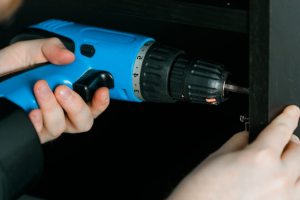hands holding a blue electric screwdriver
