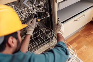 handyman making repairs to a dishwasher