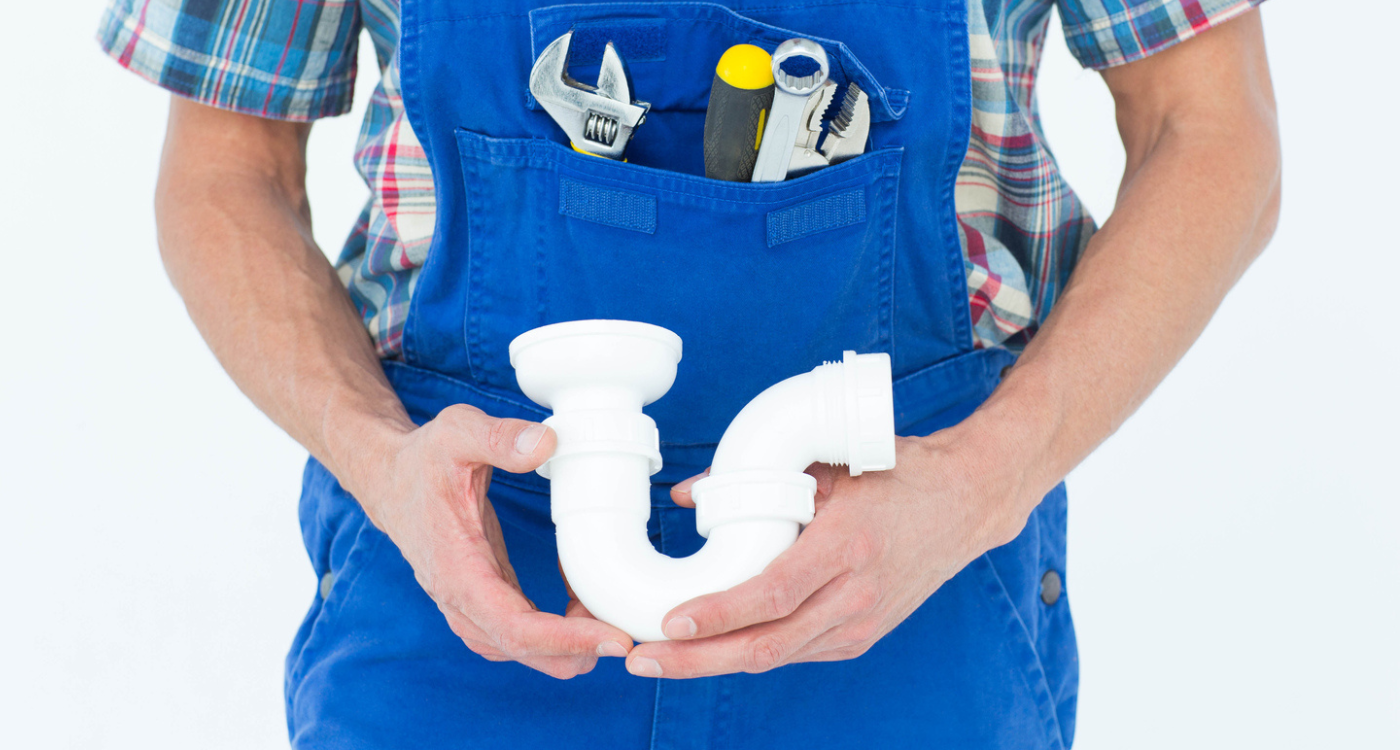a plumber holding a U-bend sink pipe